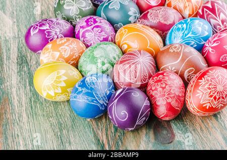 Varietà di colorate uova di pasqua graffiate a mano su tavola di legno Foto Stock