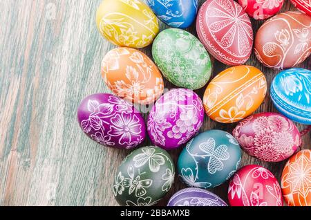 Varietà di colorate uova di pasqua graffiate a mano su tavola di legno Foto Stock