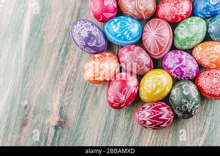 Varietà di colorate uova di pasqua graffiate a mano su tavola di legno Foto Stock