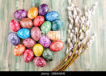 Varietà di colorate uova di pasqua graffiate a mano su tavola di legno Foto Stock