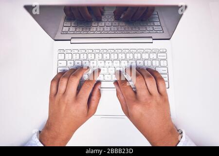 Man mano sulla tastiera del notebook con schermo vuoto monitor Foto Stock