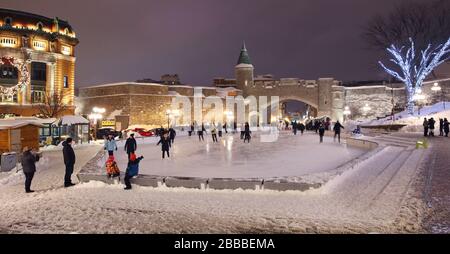 Pista di pattinaggio in Place d'Youville con le mura delle fortificazioni del Quebec sullo sfondo, tra cui la porta di San Giovanni, Quebec City, Quebec, Canada Foto Stock