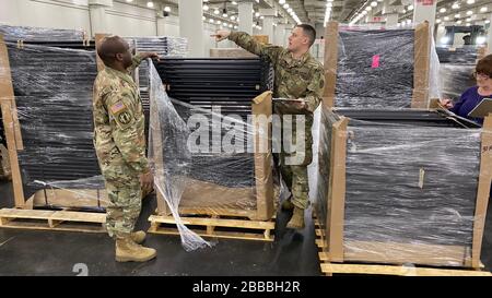 New York Army National Guard Soldiers della 133rd Composite Supply Company, parte del 53rd Troop Command, magazzino e inventario le spedizioni iniziali di un FEMA Field Hospital per la messa a punto presso il Jacob Javits Convention Center di New York City, 25 marzo 2020. Il Javits Center sarà convertito in una struttura medica temporanea per alleviare la carenza di letti degli ospedali di New York come parte della risposta statale al focolaio di COVID 19. Oltre 2.000 soldati della Guardia Nazionale di New York e Airmen sono in servizio come parte dello sforzo di risposta. (STATI UNITI Foto Air National Guard di Senior Airman Sea Foto Stock