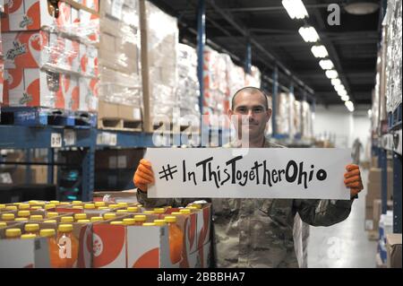 SGT. Terry Boyd, assegnato alla Ohio Military Reserve, condivide un messaggio di solidarietà mentre serve alla Toledo Northwestern Ohio Food Bank, 26 marzo 2020. Quasi 400 membri della Guardia Nazionale dell'Ohio sono stati attivati per fornire missioni umanitarie a sostegno degli sforzi di soccorso della COVID-19, continuando la lunga storia della Guardia Nazionale dell'Ohio di sostenere gli sforzi umanitari in tutto l'Ohio e la nazione. Foto della Guardia Nazionale aerea del Master Senior Sgt. Beth Holliker. Foto Stock