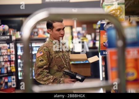 SGT. Alejandro Sanchez, 158 Charlie Company infantryman, magazzino scaffali in un negozio di alimentari locale a sostegno di Pima County, Ariz., 28 marzo 2020. La Guardia Nazionale dell'Arizona ha attivato più di 700 soldati cittadini e Airmen dell'Arizona per sostenere i negozi di alimentari, le banche alimentari e altre esigenze della comunità durante questo stato di risposta di emergenza (Stati Uniti Foto Air National Guard di Tech. SGT. Michael Matkin). Foto Stock