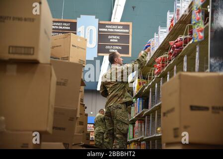 SGT. Jonathan Cunningham, ingegnere di combattimento della 819th Engineer Company, immagazzina gli scaffali in un deposito locale della drogheria per aumentare la capacità e la capacità a Phoenix, Ariz., 28 marzo 2020. La Guardia Nazionale dell'Arizona ha attivato più di 700 soldati cittadini e Airmen dell'Arizona per sostenere i negozi di alimentari, le banche alimentari e altre esigenze della comunità durante questo stato di risposta di emergenza (Stati Uniti Foto Air National Guard di Tech. SGT. Michael Matkin). Foto Stock