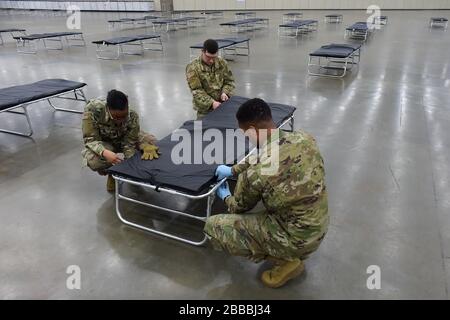 Soldati con la Guardia Nazionale dell'Esercito del Maryland assemblare una culla come parte della creazione di una Stazione Medica Federale nel Centro Congressi di Baltimora, a Baltimora, Maryland, Sabato, 28 Marzo 2020. Progettata per essere utilizzata come centro medico alternativo, la stazione è stata creata per alleviare il possibile sovraffollamento negli ospedali della zona a causa dell'epidemia di COVID-19. Circa 100 soldati hanno assistito con la messa a disposizione di 250 posti letto e attrezzature correlate nel centro congressi, mentre a livello nazionale quasi 14.000 membri della Guardia Nazionale sono in servizio fornendo forniture, la gestione di centri di test mobili e di lavoro Foto Stock