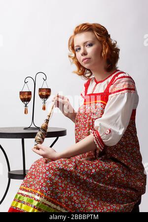 ritratto di bella ragazza slava redhead in tradizionale abito folk russo con distaff Foto Stock