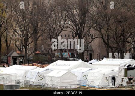 New York City, New York, Stati Uniti. 30th Mar, 2020.Workers mettere il tocco finale su un ospedale di emergenza nel Central Park di New York City per affrontare la pandemia di coronavirus. L'organizzazione cristiana del North Carolina, la Purse di Samaritan, ha iniziato ieri a costruire un ospedale di campo di emergenza da 68 posti letto di fronte all'ospedale del Monte Sinai e si prevede che sarà operativo martedì, marzo 31st. L'ospedale sul campo sarà composto da un'unità di terapia respiratoria con capacità ICU. Credito: Adam Stoltman/Alamy Live News Foto Stock