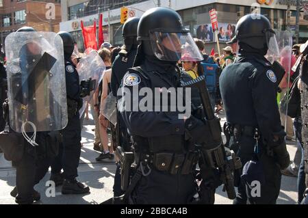 Migliaia di attivisti marciano lungo la strada del College del centro di Toronto, partecipando a una protesta in anticipo Foto Stock