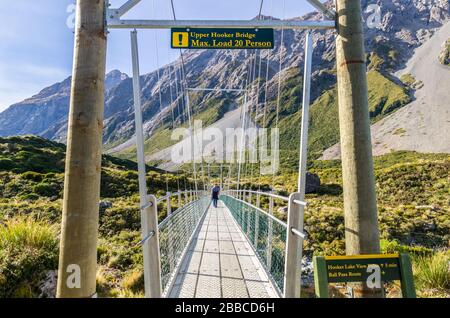 I viaggiatori possono vedere trekking lungo l'Upper Hooker Bridge nel Mount Cook National Park, Nuova Zelanda. Foto Stock