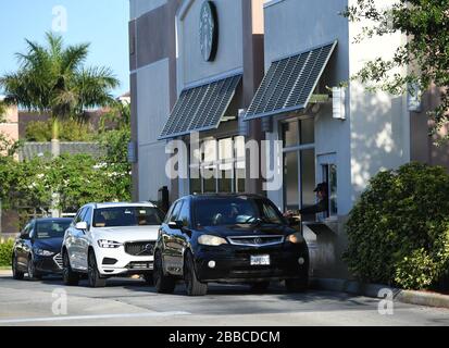 Coconut Creek, Florida, Stati Uniti. 30th Mar, 2020. Le automobili si allineano al drive-through Starbucks poiché tutti i negozi e i ristoranti hanno chiuso le loro porte ai ristoranti interni a causa della pandemia di Coronavirus (COVID-19) il 30 marzo 2020 a Coconut Creek, Florida. Credito: Mpi04/Media Punch/Alamy Live News Foto Stock