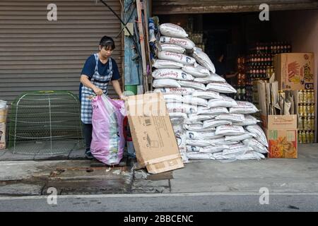 SAMUT PRAKAN, THAILANDIA, 14 MARZO 2020, una donna pulisce davanti prima di fare acquisti con borse piene di terreno. Foto Stock