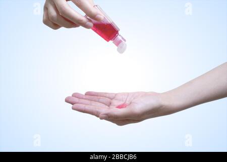 Gel di lavaggio a mano rosso sulle mani per pulire e proteggere i batteri. Mano di donna che applica il gel di alcool per rendere la pulizia isolata con il percorso di Clipping. Foto Stock