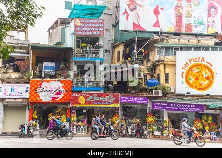 HANOI, VIETNAM - 19TH MARZO 2017: Strade di Hanoi che mostrano l'esterno di negozi, scooter e persone Foto Stock