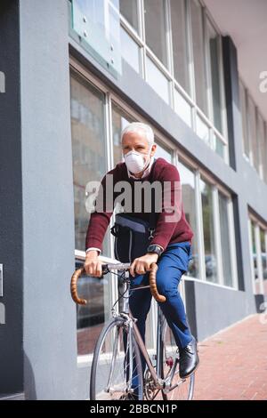 Uomo di mezza età che indossa la maschera di coronavirus Covid 19 in movimento Foto Stock