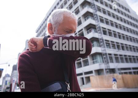 Uomo di mezza età che indossa la maschera di coronavirus Covid 19 in movimento Foto Stock