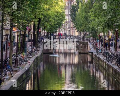 Riflessioni in un canale circondato da biciclette ad Amsterdam, nei Paesi Bassi Foto Stock