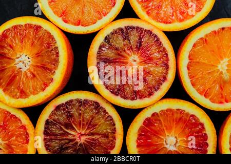Fondo di Jucy fatto di fette di arancio del sangue su sfondo nero Foto Stock
