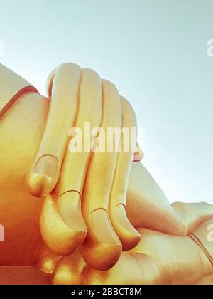 Avvicinati la mano della grande statua del buddha con il cielo blu a Wat Tha Muang Thailand, le statue più iconiche del Buddha d'oro Foto Stock