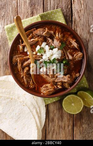 Birria de Res messicana servita con calce e tortilla in una ciotola sul tavolo. Vista dall'alto verticale Foto Stock