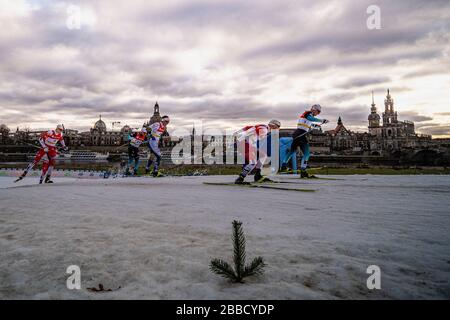 Uomini che corrono alla FIS sci di fondo sprint Coppa del mondo sulle rive del fiume Elba, lo skyline della città barocca in lontananza Foto Stock