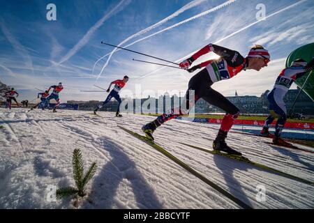 Uomini che corrono alla FIS sci di fondo sprint Coppa del mondo sulle rive del fiume Elba, lo skyline della città barocca in lontananza Foto Stock