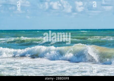 bellissimo panorama sul mare. Onde di mare in schiuma sotto cielo blu. Immagine tonata. Foto Stock