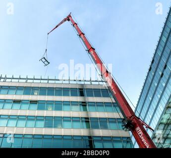 Caricare la gru con un gancio mentre si lavora su un alto edificio nel centro di Berlino Foto Stock