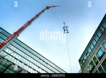 Caricare la gru con un gancio mentre si lavora su un alto edificio nel centro di Berlino Foto Stock