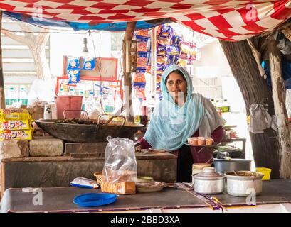 Una donna venditore in una tradizionale stalla di cibo di strada in India Foto Stock