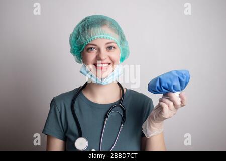 Donna sorridente medico infermiera in uniforme con borsa di ghiaccio blu Foto Stock