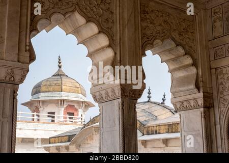 Vista di una torre attraverso un elaborato arco al Forte di Agra in India Foto Stock