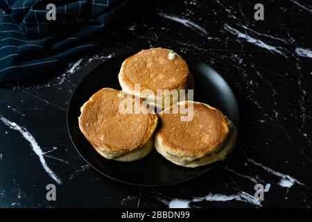 Frittella di panciole semplice fatta in casa in piatto nero pronto a mangiare per la colazione. Foto Stock