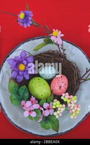 Tavola di Pasqua, luogo impostazione. Decorazione di Pasqua su un piatto, tovaglia rossa, vista dall'alto. Tavolo della celebrazione cristiana ortodossa di Pasqua Foto Stock