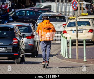Essen, Ruhr Area, Renania Settentrionale-Vestfalia, Germania - Servizio di consegna Lieferando, un autista di corriere sulla strada con uno scooter elettrico consegna l'ordigno Foto Stock