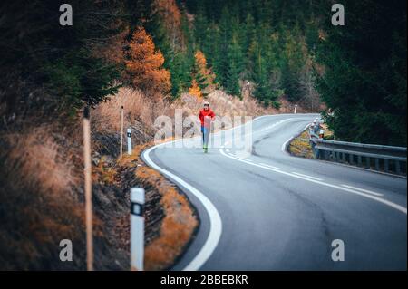 Runner corrono su colline sulla strada in autunno natura Foto Stock