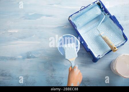 Mano mette spazzola in vaso di vernice Foto Stock