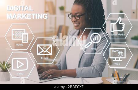 African American business lady che lavora in ufficio, collage con le icone di marketing digitale sullo schermo virtuale Foto Stock