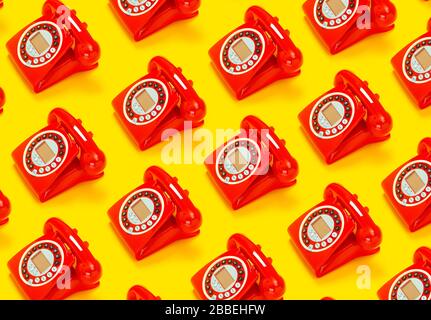 Un telefono rosso retrò su sfondo giallo. Foto Stock