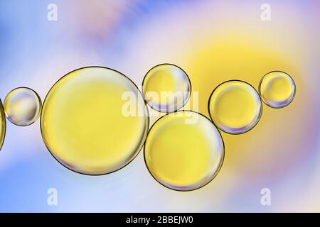 Coloratissimo primo piano di gocce d'olio che galleggiano sull'acqua Foto Stock