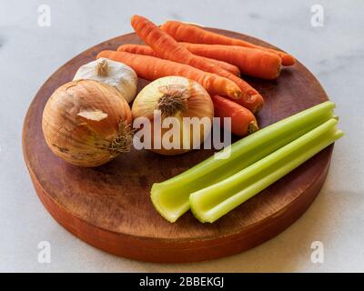 Vista delle verdure crude ingredienti mirepox - cipolle, sedano e carote su una tavola di legno Foto Stock