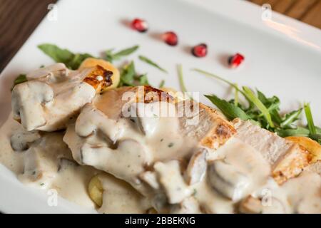Pollo su gnocchi grattugiati in salsa di funghi e formaggio affumicato sul tavolo Foto Stock