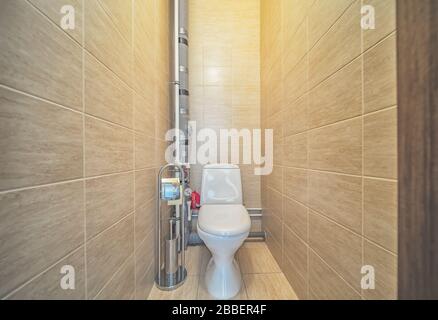 WC in bagno. Servizi igienici con decorazioni e pavimenti in piastrelle beige Foto Stock