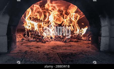 Fuoco rosso caldo che brucia all'interno di un forno a legna per pizza con fiamme rosse di arancio Bulgaria Foto Stock