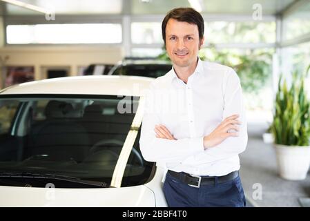 Uomo e donna in un concessionario di auto, l'acquisto di un'auto, acquirenti e venditori Foto Stock