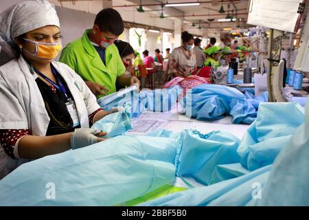 Dhaka, Bangladesh - 31 marzo 2020: Lavoratori che producono dispositivi di protezione individuale (PPE) per gli operatori sanitari presso una fabbrica di abbigliamento del Gruppo Urmi Foto Stock