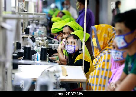 Dhaka, Bangladesh - 31 marzo 2020: Lavoratori che producono dispositivi di protezione individuale (PPE) per gli operatori sanitari presso una fabbrica di abbigliamento del Gruppo Urmi Foto Stock