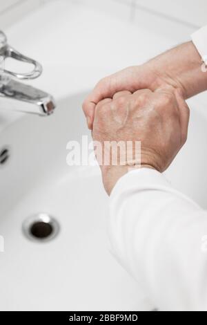 il medico maschio sta lavando le sue mani con sapone, poi usa liquido di disinfezione, concetto di virus corona o covid-19, sars-cov-2 Foto Stock