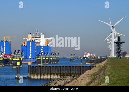 Rotterdam, Paesi Bassi-marzo 2020: Vista sulla fila di navi cisterna per prodotti chimici e petroliferi ormeggiate e di navi per sollevamento pesante; mulini a vento allineati a destra; Foto Stock